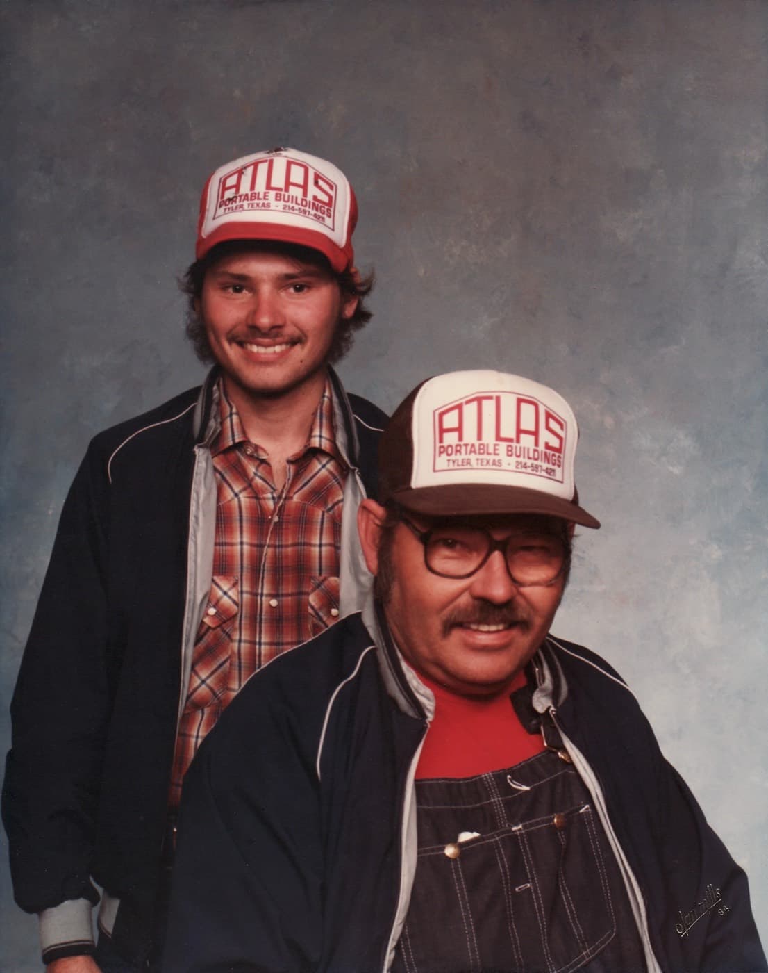 William F. Downs, Sr. and William Jr. in Atlas Portable Buildings caps, 1984